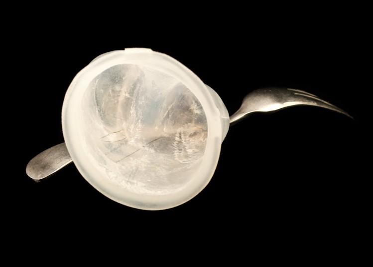 Studio shot of the fork/silicone unit, showing the silicone cap's hollow opening that fits onto Cindy's hand. The fork is visible protruding out of the left and right side of the silicone cap.