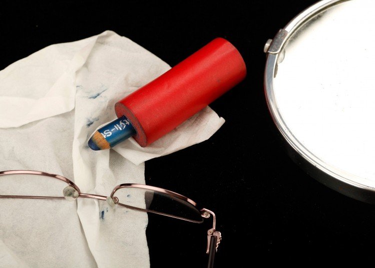 A studio shot of Cindy's eyeliner, glasses, a handkerchief, and a small vanity mirror: a glimpse of her self care.