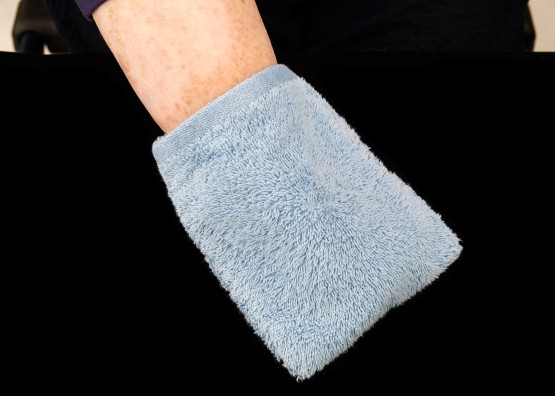 Cindy's hand covered by the blue washcloth. This is one of her key daily care devices.
