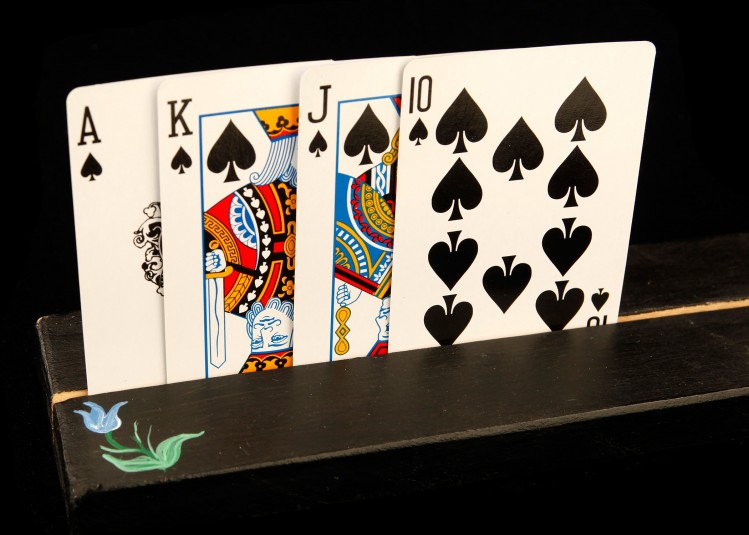Close-up of the flower end of the card holder, with four cards visible (Ace, King, Jack, Ten).