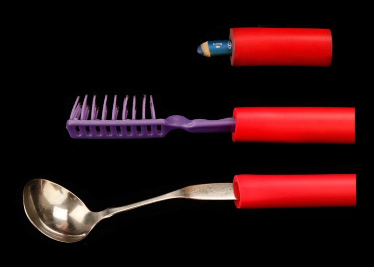 Three household tools that Cindy has adapted with red rubber tubing around their 